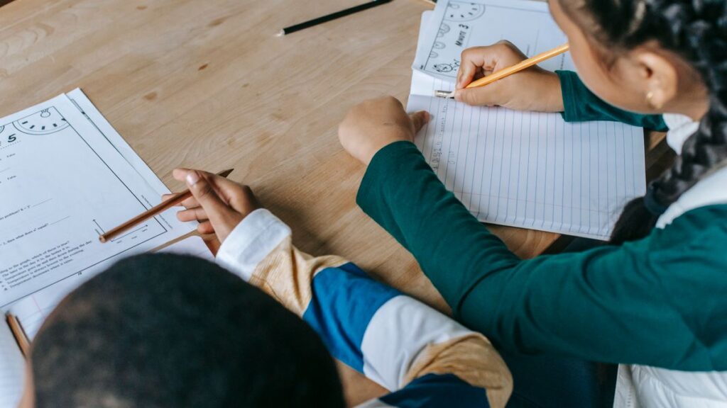 Informal letter format practice by students writing in notebooks