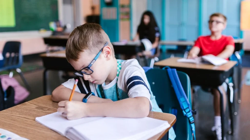 Students in class writing an application to principal